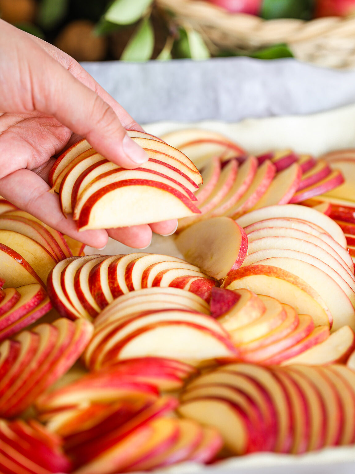 hand-placing-apple-slices-on-puff-pastry-sheet